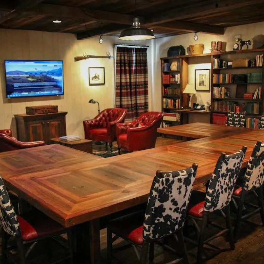 Comforts include upholstered chairs, a flat-screen TV, a wrap-around table and bookshelves filled with Western classics.